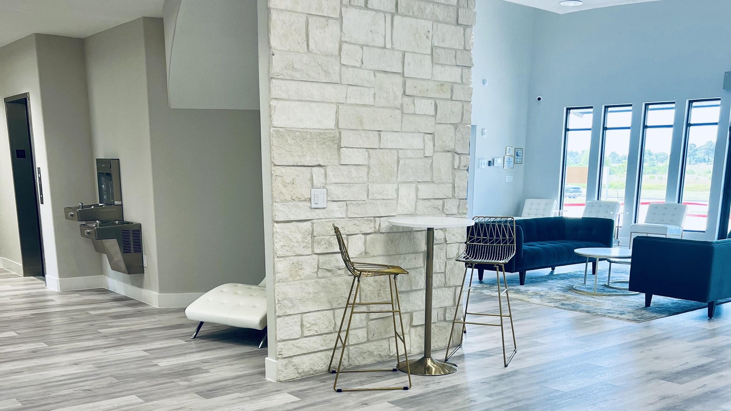 Common area hallway with stacked stone feature and lounge seating at Bellevana